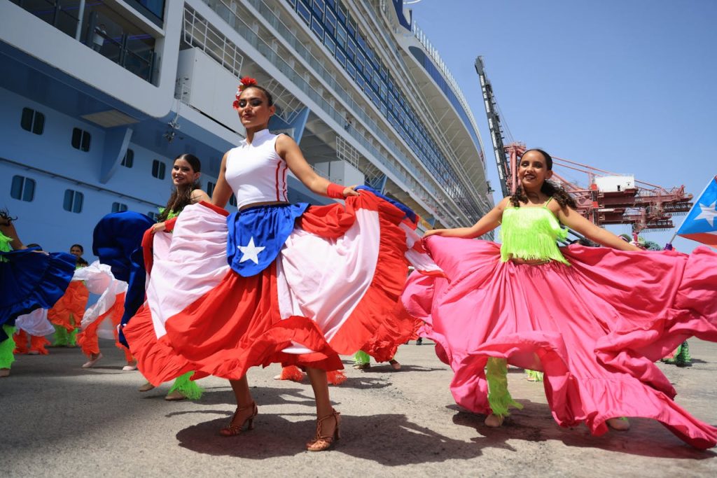 Colorful dancers in traditional attire celebrating at a cruise port in Puerto Rico.